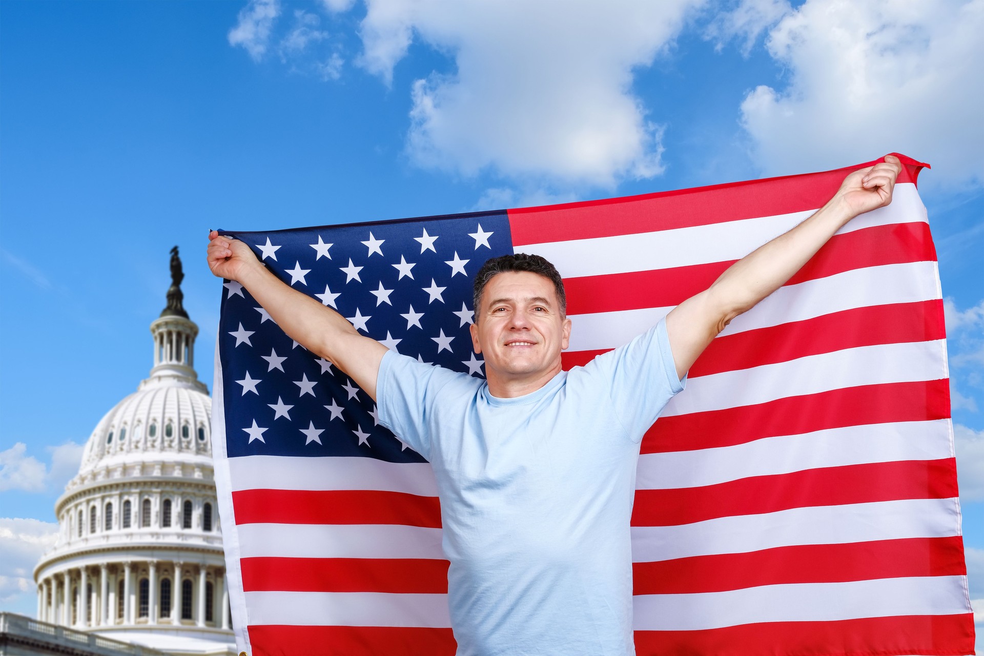 Man holds American flag in outstretched arms